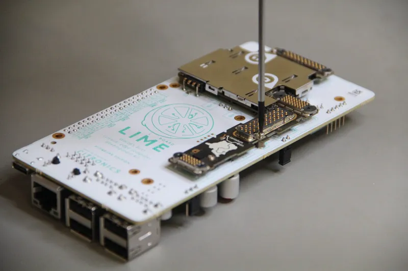 A qualified module seated on a white Limeboard carrier with Ethernet and USB ports, a probe pin resting on it